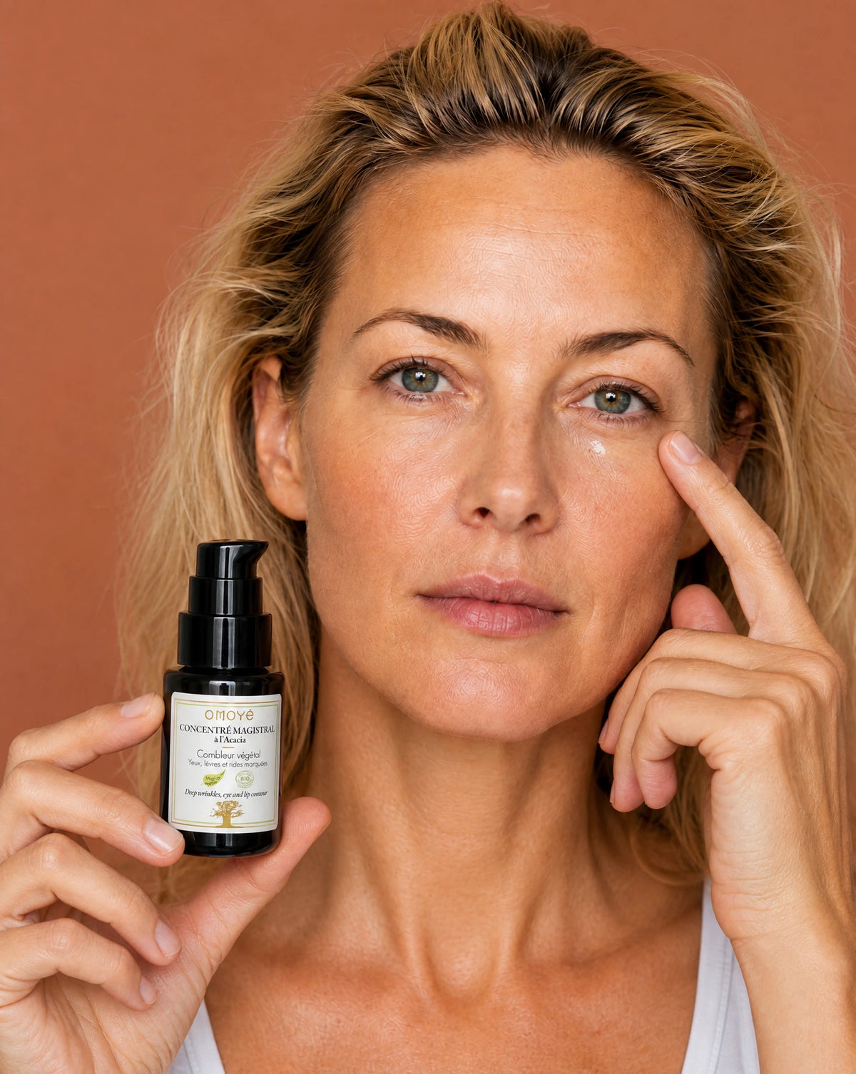 Application d'une goutte de Concentré Magistral Omoyé sous l'œil, soin ciblé contour des yeux anti-rides