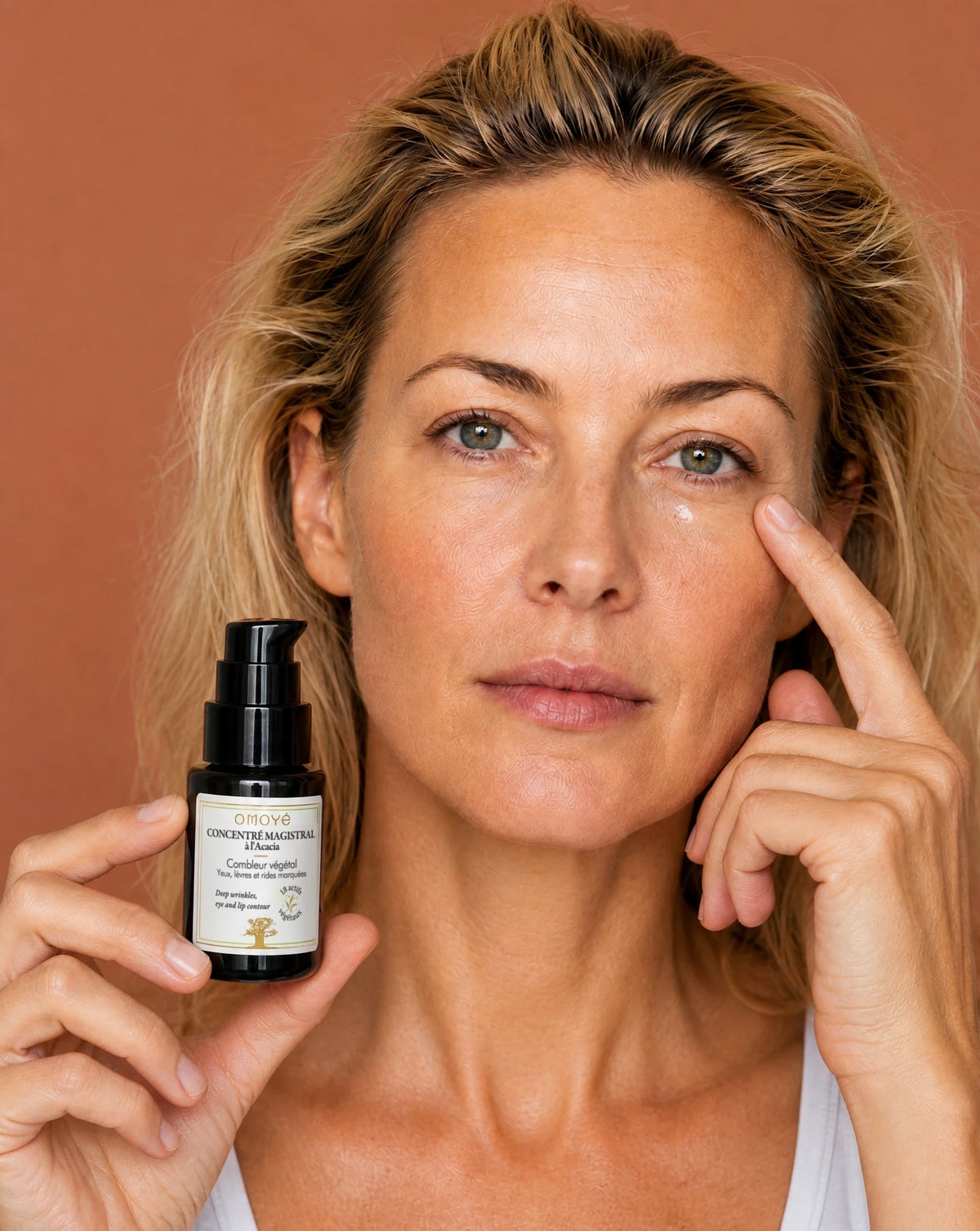 Application d'une goutte de Concentré Magistral Omoyé sous l'œil, soin ciblé contour des yeux anti-rides